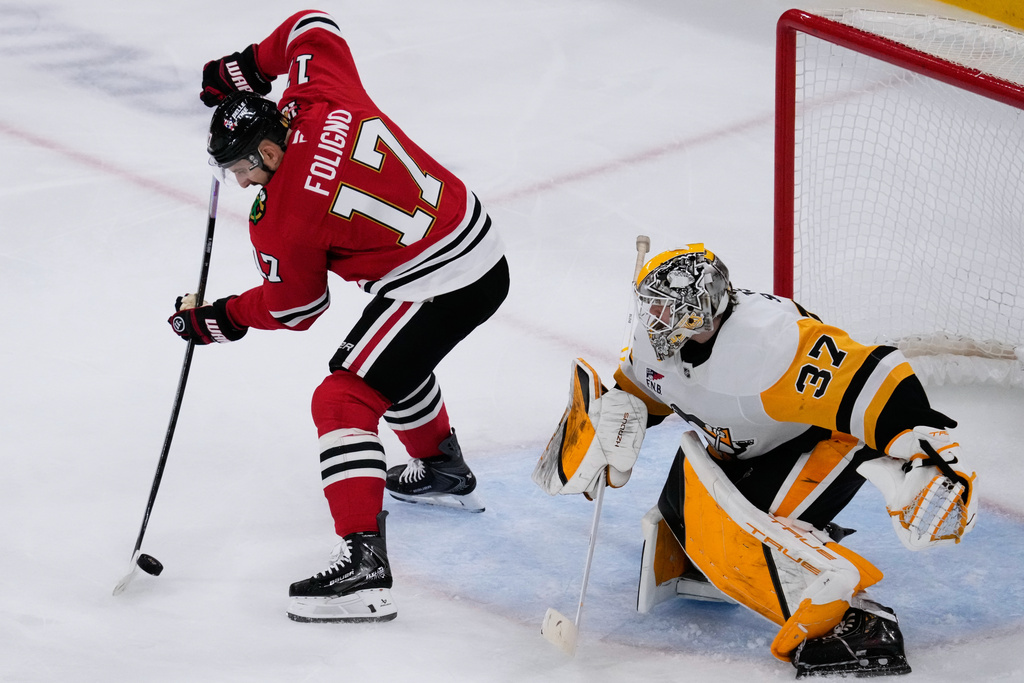 Chicago Blackhawks left wing Nick Foligno, left, scores against Pittsburgh Penguins goaltender Arturs Silovs during the second period of an NHL hockey game in Chicago, Sunday, Dec. 28, 2025. (AP Photo/Nam Y. Huh)