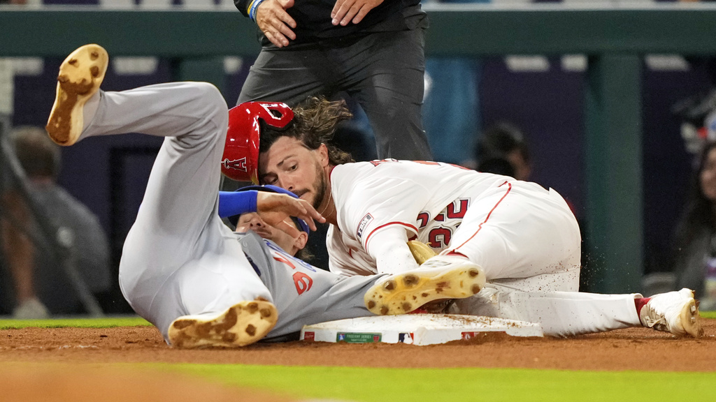 Los Angeles Angels' Bryce Teodosio, right, is tagged out by Los Angeles Dodgers third baseman Alex Freeland as he tries to steal third during the seventh inning of a baseball game Wednesday, Aug. 13, 2025, in Anaheim, Calif. (AP Photo/Mark J. Terrill)