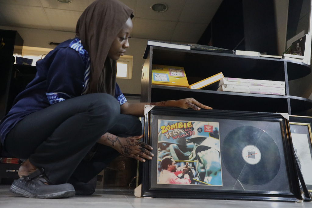 Qawiyat Omizi, a tour guide holds the album cover of Fela Kuti's song Zombie at Kalakuta Museum in Lagos, Nigeria. Saturday, May 30, 2026. (AP Photo/Mansur Ibrahim)