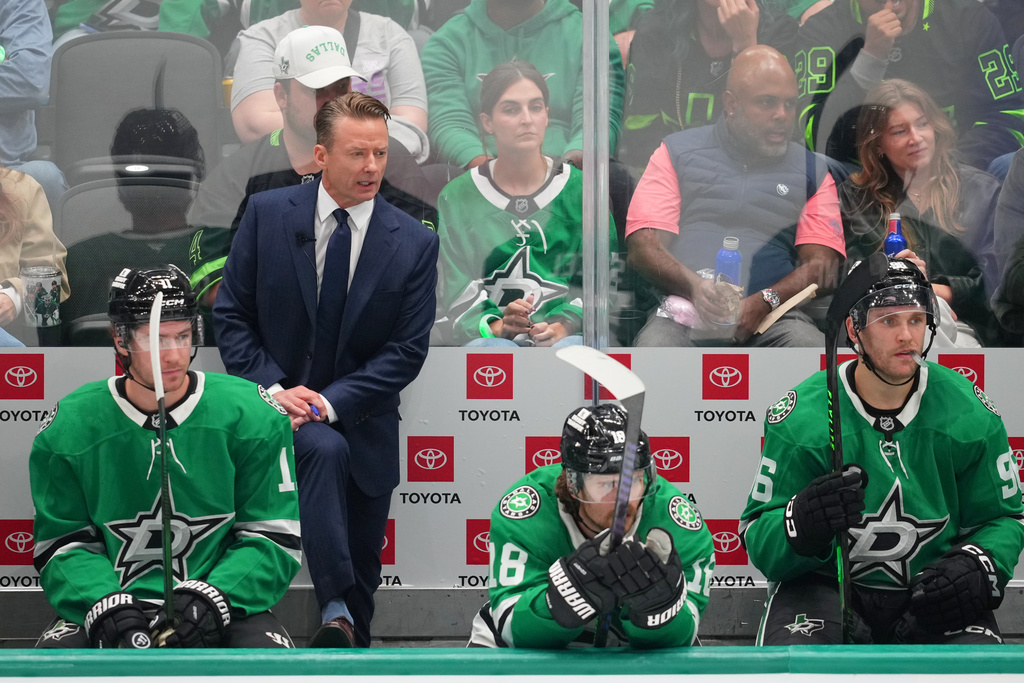Dallas Stars head coach Glen Gulutzan, top left, looks on during the third period of an NHL hockey game against the Minnesota Wild Tuesday, Oct. 14, 2025, in Dallas. (AP Photo/Julio Cortez)