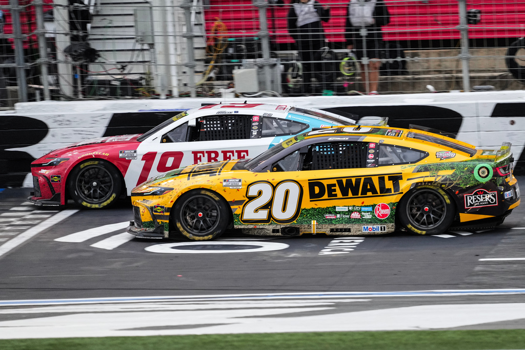 Chase Briscoe (19) beats Christopher Bell (20) to the finish line to win a NASCAR Cup Series auto race, Sunday, Oct. 11, 2026, in Concord, N.C. (AP Photo/Matt Kelley)