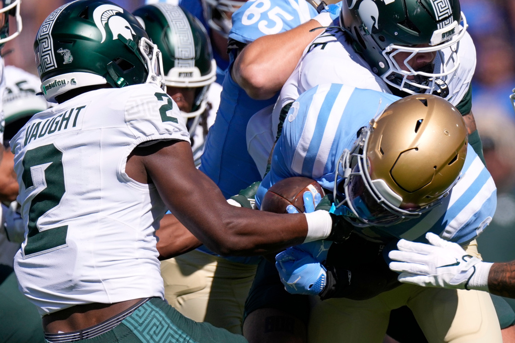 Michigan State safety Devin Vaught, left, strips the ball from UCLA running back Anthony Woods during the first half of an NCAA college football game, Saturday, Oct. 24, 2026, in Pasadena, Calif. (AP Photo/Mark J. Terrill)