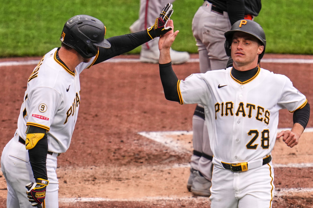 Pittsburgh Pirates' Jake Mangum (28) high-fives teammate Ryan O'Hearn after scoring a run during the second inning of a baseball game in Pittsburgh, Sunday, April 5, 2026. (AP Photo/Gene J. Puskar)