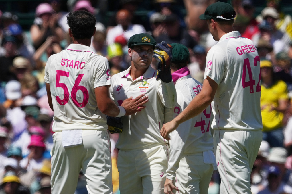 Australia's Mitchell Starc, left, is congratulated by teammates Alex Carey and Cameron Green, right, after dismissing England's Ben Duckett during play on day one of the fifth and final Ashes cricket test between England and Australia in Sydney, Sunday, Jan. 4, 2026. (AP Photo/Mark Baker)