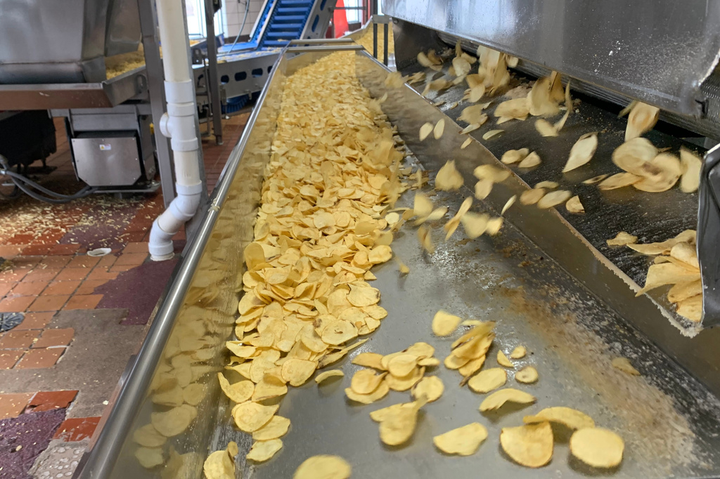 Potato chips move along a conveyor at a Better Made Snack Foods processing facility in Detroit, on Thursday, April 2, 2026 (AP Photo/Mike Householder)
