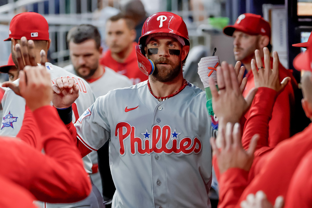 Philadelphia Phillies' Bryce Harper is greeted in the dugout after scoring against the Atlanta Braves during the first inning of a baseball game, Saturday, April 25, 2026, in Atlanta. (AP Photo/Erik S. Lesser)