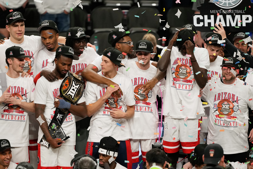 Arizona players celebrate after winning an NCAA college championship basketball game against Houston at the Big 12 Conference tournament Saturday, March 14, 2026, in Kansas City, Mo. (AP Photo/Charlie Riedel)