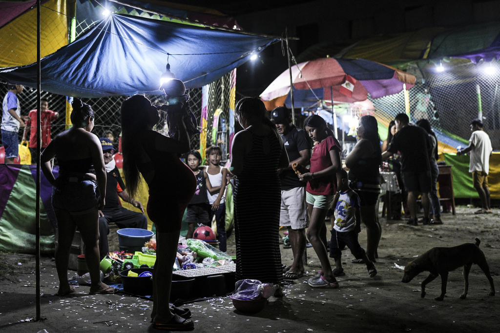 Residents attend a town fair in Santa Rosa, Peru, an island on the Amazon River at the triple border with Colombia and Brazil, Sunday, Aug. 17, 2025. (AP Photo/Ivan Valencia)