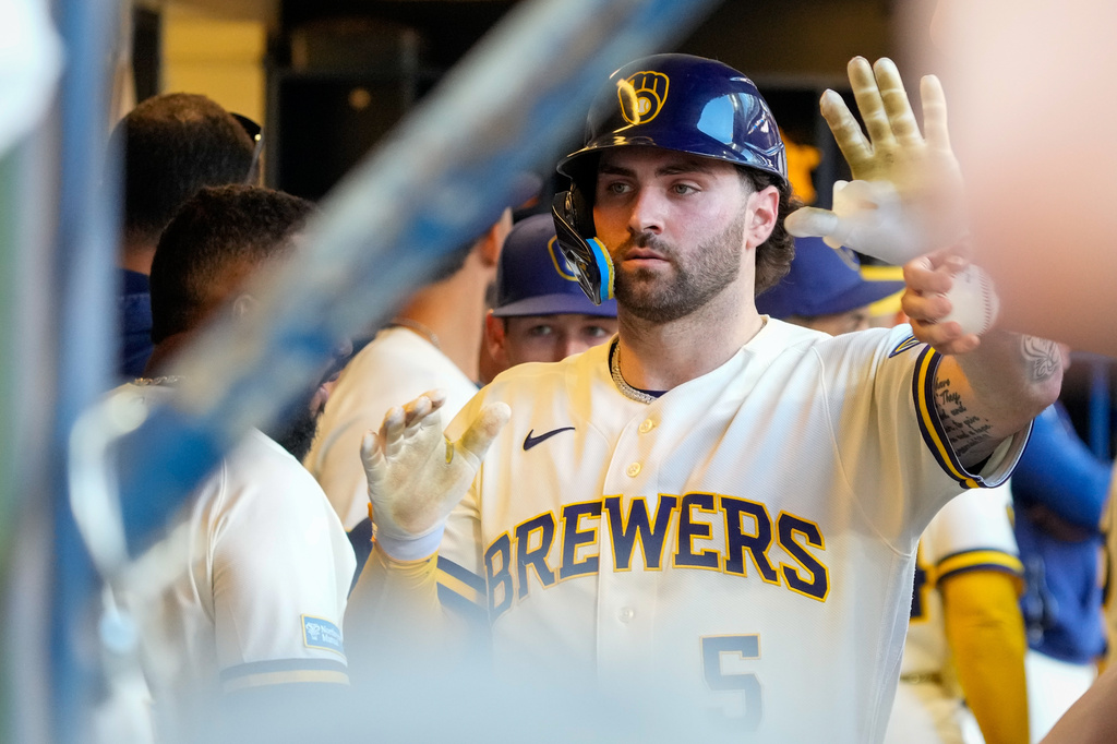 Milwaukee Brewers' Garrett Mitchell high-fives teammates after scoring on an RBI single hit by Christian Yelich during the eighth inning of a baseball game against the St. Louis Cardinals Wednesday, May 27, 2026, in Milwaukee. (AP Photo/Kayla Wolf)