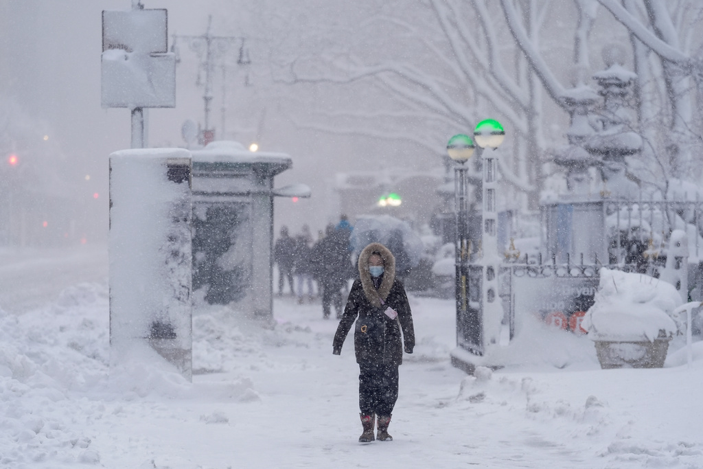 A pedestrian walks along 42nd Street near Bryant Park during a snow storm, Monday, Feb. 23, 2026, in New York. (AP Photo/Seth Wenig)