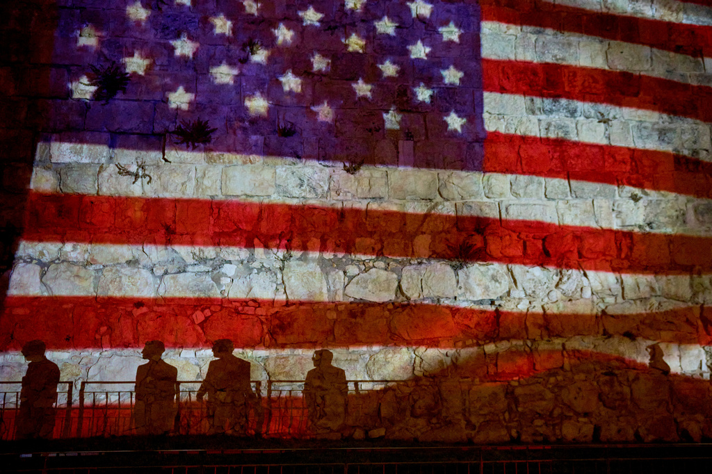 FILE - Pedestrians are silhouetted against a projection of the American flag on the walls of Jerusalem's Old City, July 5, 2026, displayed in honor of the 250th anniversary of U.S. independence. (AP Photo/Ohad Zwigenberg, File)