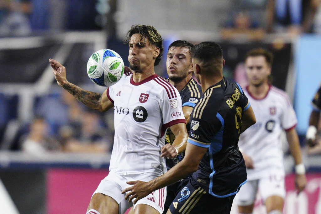 Toronto FC's Theo Corbeanu, left, plays the ball past Philadelphia Union's Kai Wagner, center front, and Tai Baribo (9) during the first half of an MLS soccer match, Saturday, Aug. 9, 2025, in Chester, Pa. (AP Photo/Derik Hamilton)