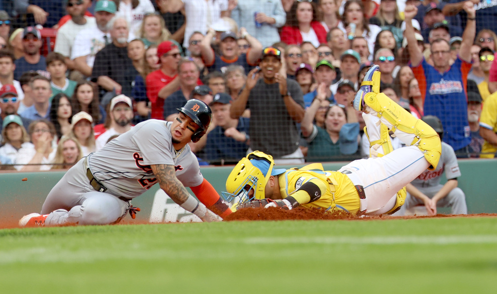 Detroit Tigers' Javier Báez (28) slides safely into home plate as Boston Red Sox catcher Carlos Narváez attempts the out during the fifth inning of a baseball game, Saturday, Sept. 27, 2025, in Boston. (AP Photo/Mark Stockwell)