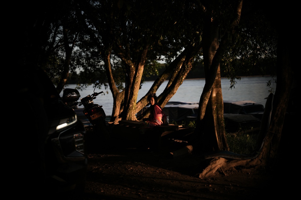 A girl waits at the port in Puerto Asis, Colombia, Wednesday, Nov. 26, 2025. (AP Photo/Ivan Valencia)