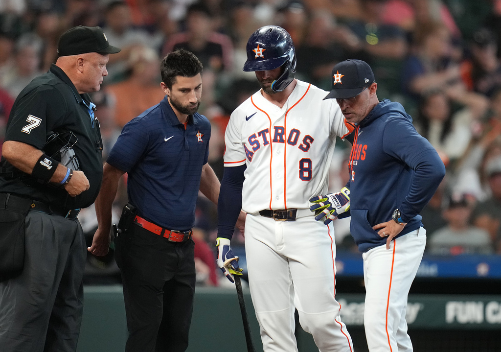 Houston Astros' Christian Walker is taken back to the clubhouse by a trainer and manager Joe Espada without finishing his at bat against Baltimore Orioles starting pitcher Trevor Rogers during the fourth inning of a baseball game, Saturday, July 18, 2026, in Houston. (AP Photo/Karen Warren)