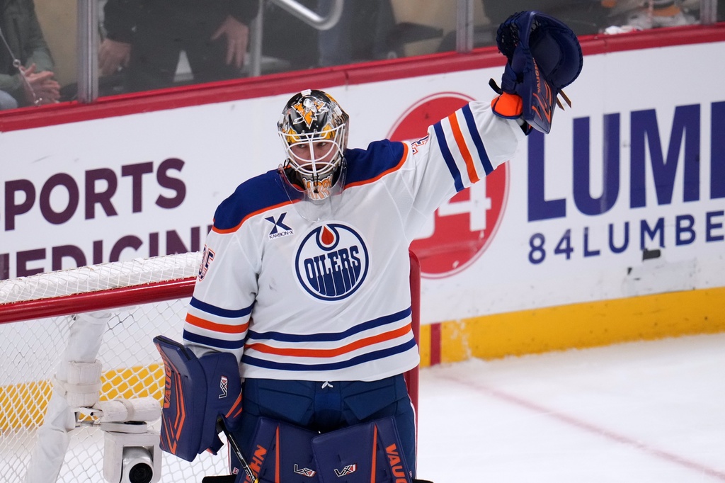 Edmonton Oilers goaltender Tristan Jarry acknowledges fans after a tribute to his time with the Pittsburgh Penguins during a first period timeout during an NHL hockey game against the Pittsburgh Penguins, in Pittsburgh, Tuesday, Dec. 16, 2025. (AP Photo/Gene J. Puskar)
