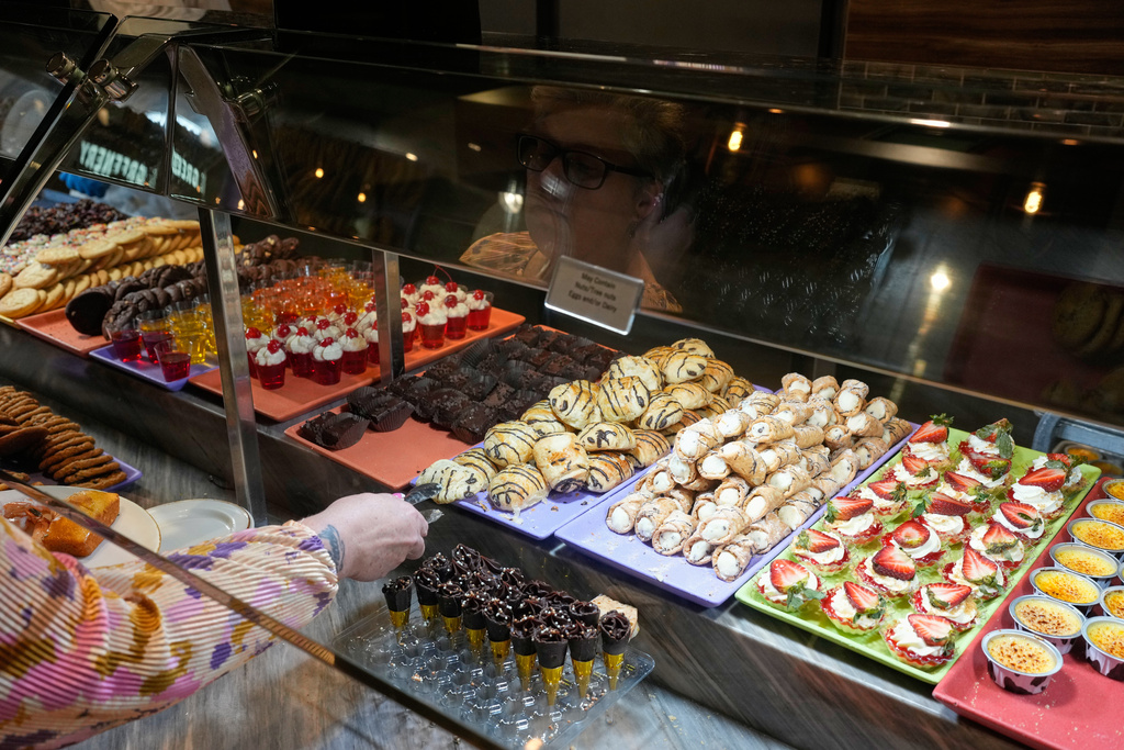 A person picks out dessert at the A.Y.C.E Buffet in the Palms resort-casino Wednesday, Jan. 28, 2026, in Las Vegas. (AP Photo/John Locher)