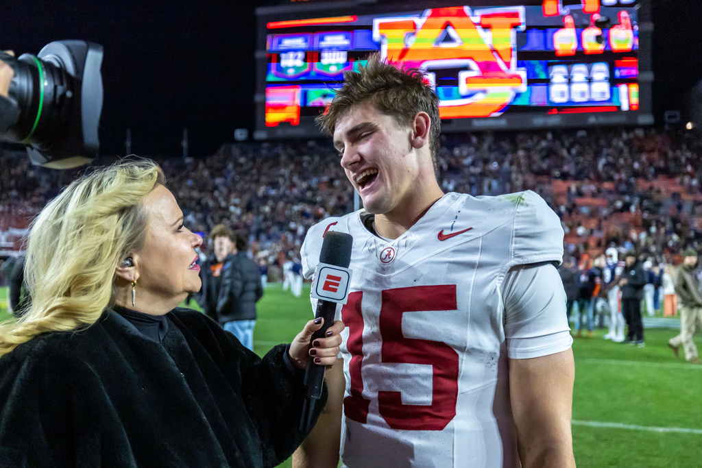 Alabama quarterback Ty Simpson (15) talks with ESPN's Holly Rowe, left, after an NCAA college football game against Auburn, Saturday, Nov. 29, 2025, in Auburn, Ala. (AP Photo/Vasha Hunt)