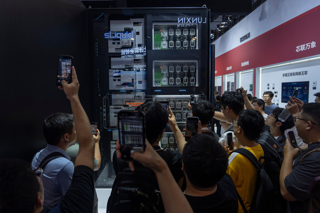 Visitors look at liquid cooled computer chips at the booth for Chinese high-performance computing and data-center technology company Sugon during the World AI Conference in Shanghai, July 18, 2026. (AP Photo/Ng Han Guan)