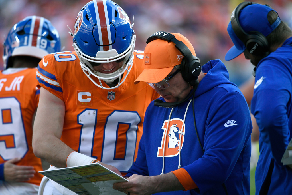 Denver Broncos head coach Sean Payton talks with quarterback Bo Nix (10) during the first half of an NFL football game against the Los Angeles Chargers in Sunday, Jan. 4, 2026, in Denver. (AP Photo/Eric Lutzens)