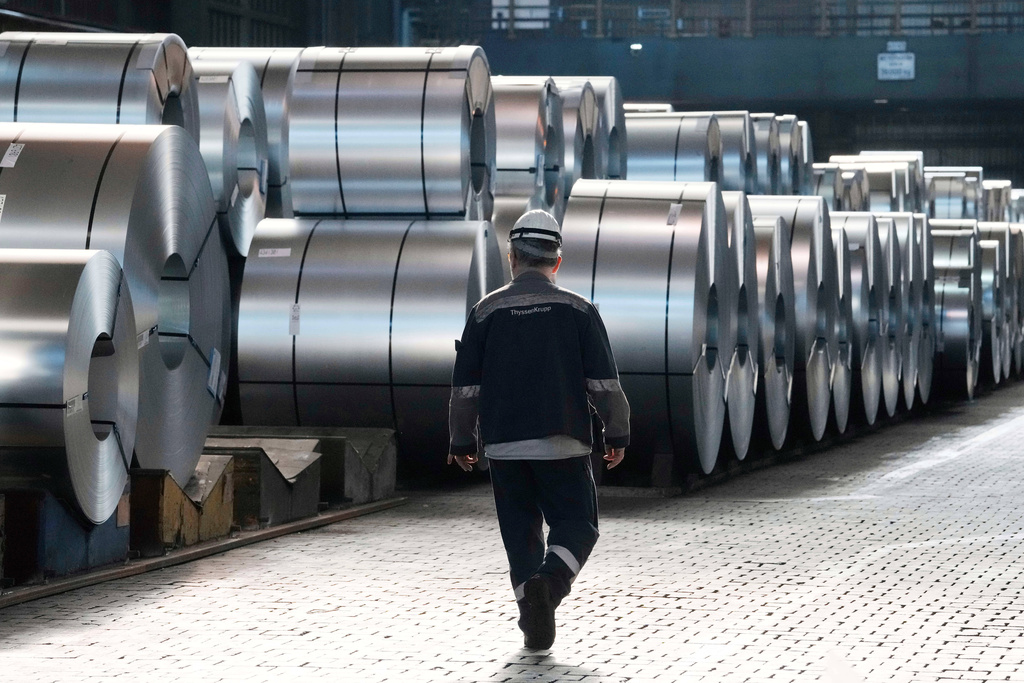 FILE - A steel worker walks beside steel coils during a visit of EU Commissioner for Prosperity and Industrial Strategy Stephane Sejourne at the Thyssenkrupp steelworks in Duisburg, Germany, after the EU Steel Action plan was presented, Thursday, March 20, 2025. (AP Photo/Martin Meissner, File)