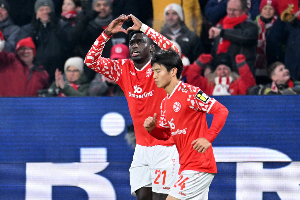 Mainz's Danny da Costa, left, celebrates with Sota Kawasaki after his goal during the German Bundesliga soccer match between FSV Mainz 05 and TSG 1899 Hoffenheim in Mainz, Germany, Friday, Nov. 21, 2025. (Torsten Silz/dpa via AP)