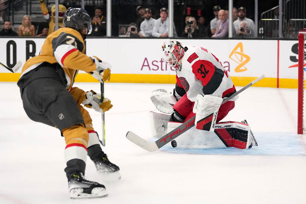 Carolina Hurricanes goaltender Brandon Bussi, right, stops a shot by Vegas Golden Knights center William Karlsson during overtime in Game 3 of the NHL hockey Stanley Cup Final series Saturday, June 6, 2026, in Las Vegas. (AP Photo/John Locher)