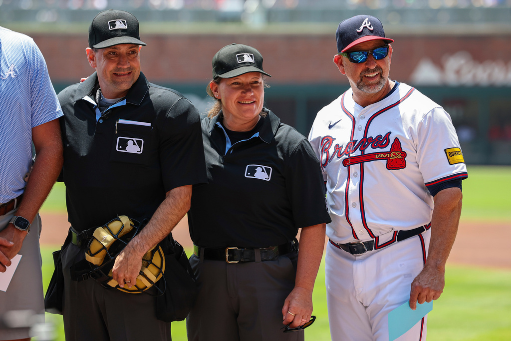 FILE - Umpires David Rackley, left, and Jan Pawol, center, pose for a photo with Atlanta Braves bench coach/infield coach Walt Weiss, right, before the start of the first baseball game of a doubleheader between the Atlanta Braves and Miami Marlins, Aug. 9, 2025, in Atlanta. (AP Photo/Colin Hubbard, File)