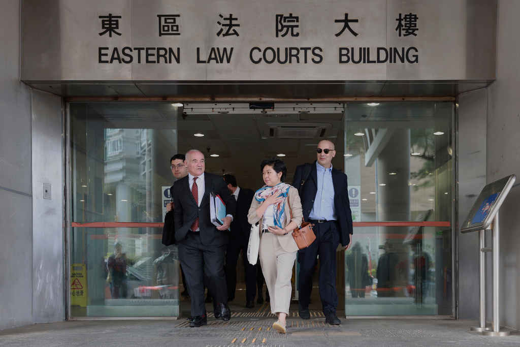 Selina Cheng, center, chair of the Hong Kong Journalists Association (HKJA) and a former reporter for The Wall Street Journal (WSJ), leaves Eastern Magistrates' Court during the session break, together with her legal team, barrister Nicklaus Pannu-Yuon, left, senior counsel Nigel Kat, second left and solicitor Adam Paul Clermont, right, for her case against the paper's parent company, Dow Jones Publishing Co (Asia) Inc., in Hong Kong on Thursday, Dec. 18, 2025. (AP Photo/May James)