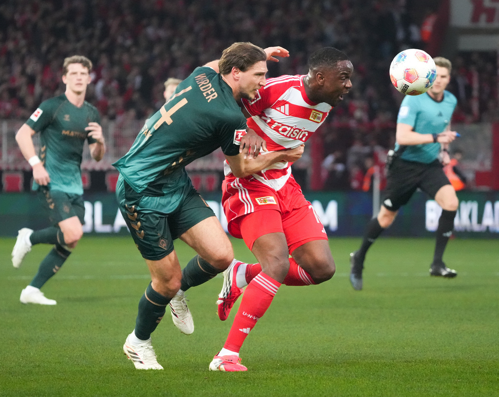 Bremen's Niklas Stark, left, and Union Berlin's Ilyas Ansah fight for the ball during the German Bundesliga soccer game between Union Berlin and Werder Bremen in Berlin, Germany, Sunday, March 8, 2026. (Soeren Stache/dpa via AP)