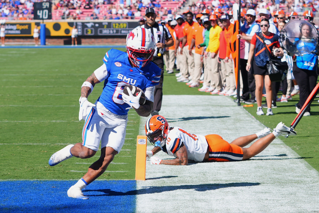 SMU running back Chris Johnson Jr. (6) scores a touchdown against Syracuse defensive back Davien Kerr (10) during the first half of an NCAA college football game Saturday, Oct. 4, 2025, in Dallas. (AP Photo/LM Otero)