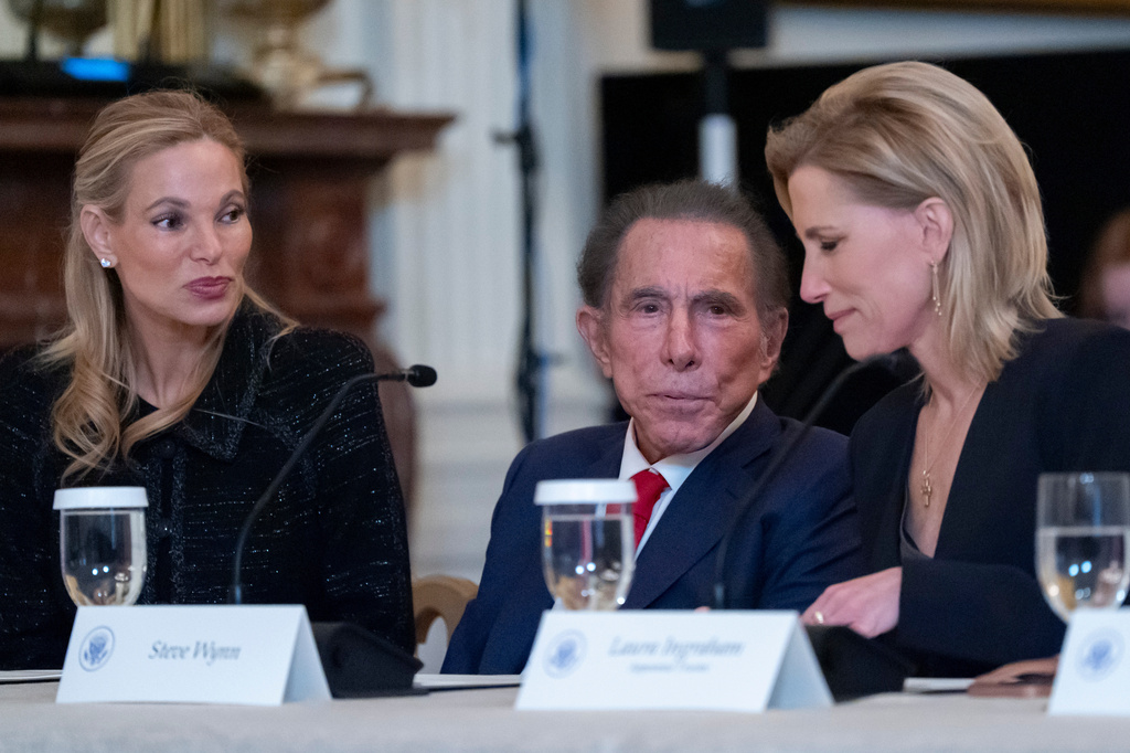 FILE - Andrea Wynn, left, her husband Steve Wynn, and Laura Ingraham talk before President Donald Trump arrives at a board meeting of the John F. Kennedy Memorial Center For The Performing Arts in the East Room of the White House, March 16, 2026, in Washington. (AP Photo/Alex Brandon, File)