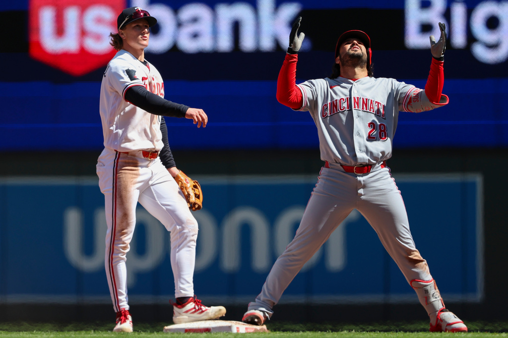 Cincinnati Reds' Eugenio Suárez (28) celebrates after hitting a double while Minnesota Twins second baseman Luke Keaschall (15) reacts during the fourth inning of a baseball game Saturday, April 18, 2026, in Minneapolis. (AP Photo/Ellen Schmidt)