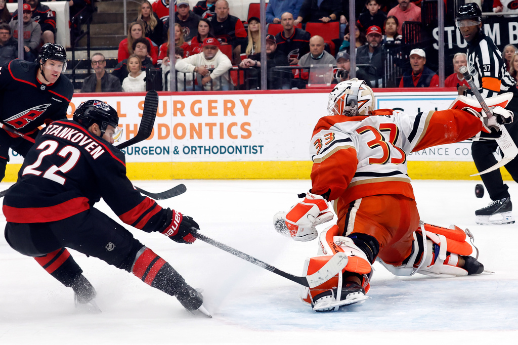 Carolina Hurricanes' Logan Stankoven (22) redirects a pass from Taylor Hall (71) past Anaheim Ducks goaltender Ville Husso (33) during the second period of an NHL hockey game in Raleigh, N.C., Thursday, Jan. 8, 2026. (AP Photo/Karl DeBlaker)