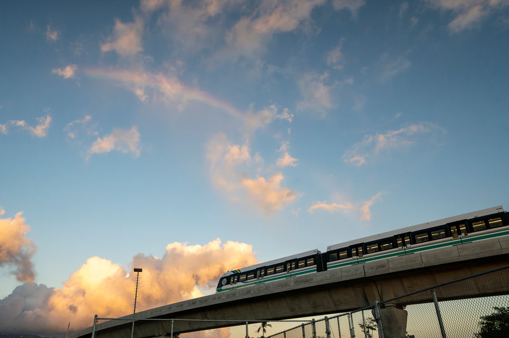 FILE - A rainbow arches over a Honolulu Skyline train at sunset, Sept. 19, 2024, in Honolulu. (AP Photo/Mengshin Lin, File)