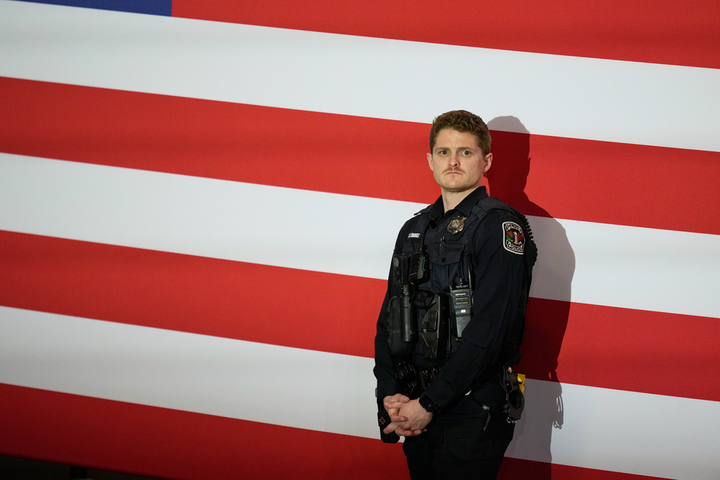 A Clive, Iowa, Police Officer looks at the crowd before President Donald Trump speaks during a rally, Tuesday, Jan. 27, 2026, in Clive, Iowa. (AP Photo/Charlie Neibergall)