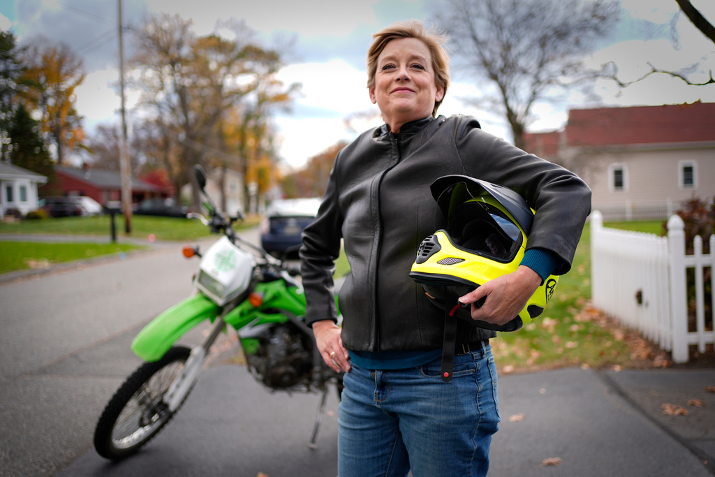 Anne Hassel, former cannabis user, poses next to her motorcycle, Nov. 6, 2025, in Chicopee, Mass. (AP Photo/Robert F. Bukaty)