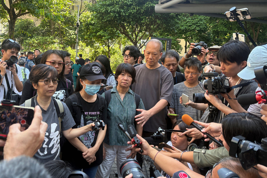 Medina Chow Lau Wah-chun, second from left in black, mother of Chow Hang-tung, and Elizabeth Tang, third from left in green stripes, wife of Lee Cheuk-yan, are flanked by supporters as they meet the media outside the court in Hong Kong, Friday, Sept. 11, 2026, after the sentencing for the Hong Kong activists who organized annual Tiananmen vigils. (AP Photo/Kanis Leung)