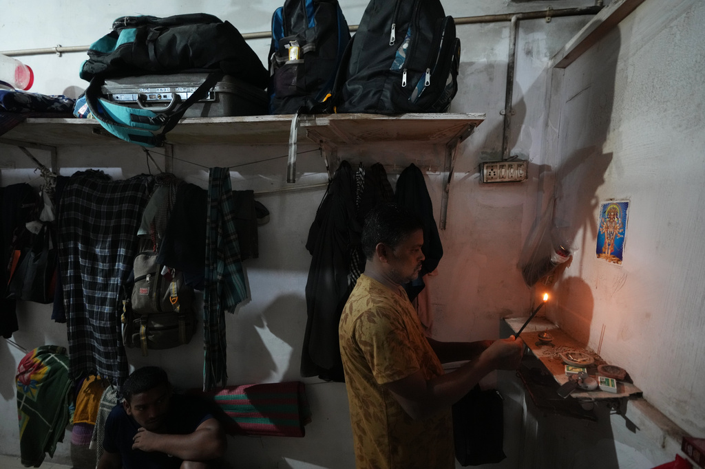 Power loom factory worker Sibaram Pradhan prays before going to work at his residential quarters in Surat, India, Thursday, May 28, 2026. (AP Photo/Ajit Solanki)