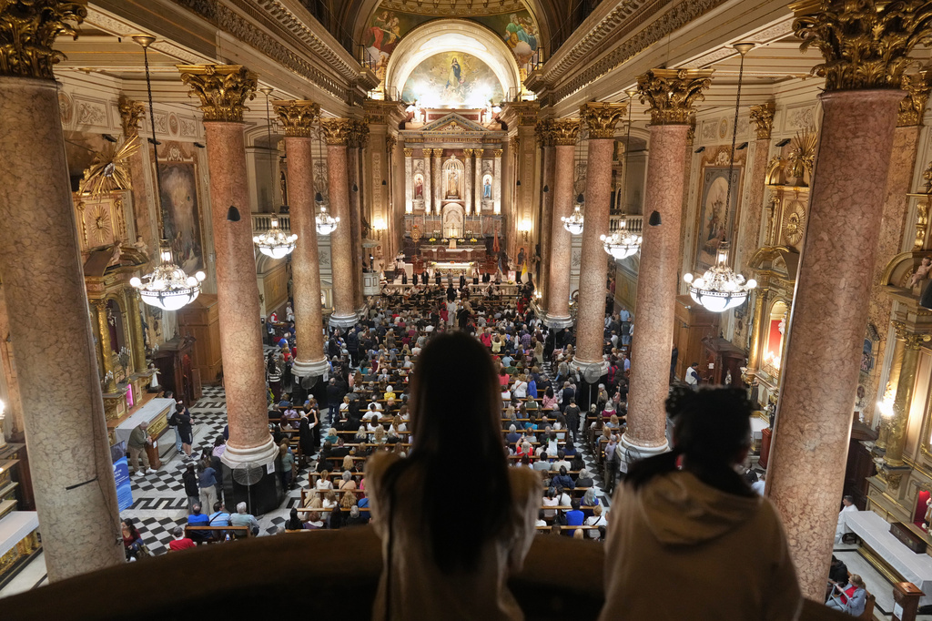 Faithful listen to musicians playing at the Basílica de San José de Flores, where the late Pope Francis worshipped as a youth, on the one-year anniversary of his passing, in Buenos Aires, Argentina, Tuesday, April 21, 2026. (AP Photo/Rodrigo Abd)