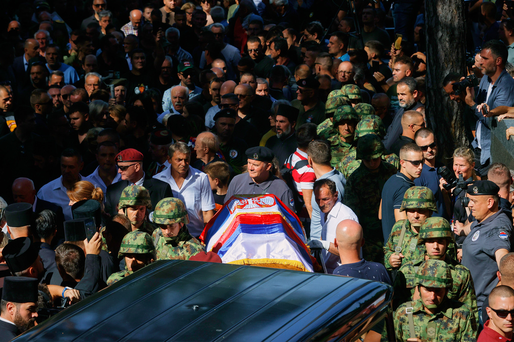 Serbian national military servicemen walk by the coffin of the former Bosnian Serb army commander Ratko Mladic, who died last week while serving a life sentence for genocide and other atrocities during the war in Bosnia, at the Topcider Cemetery, in Belgrade, Serbia, Monday, Sept. 7, 2026. (AP Photo/Marko Drobnjakovic)