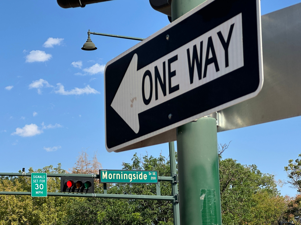 A sign notifies drivers that stoplights are set for a specific speed limit as part of the "rest on red" signal program in Albuquerque, N.M., Wednesday, Aug. 12, 2026. (AP Photo/Susan Montoya Bryan)