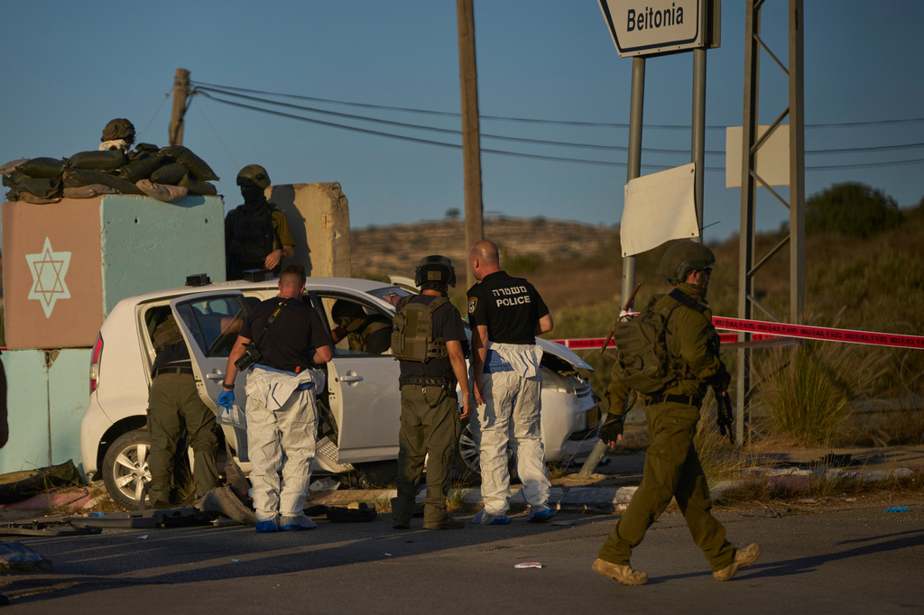 Israeli security forces inspect the scene where, according to police, a Palestinian man was shot and killed after ramming his car into a security checkpoint and seriously wounding an officer, near the West Bank Jewish settlement of Beit Horon, Wednesday, Sept. 23, 2026.(AP Photo/Ohad Zwigenberg)