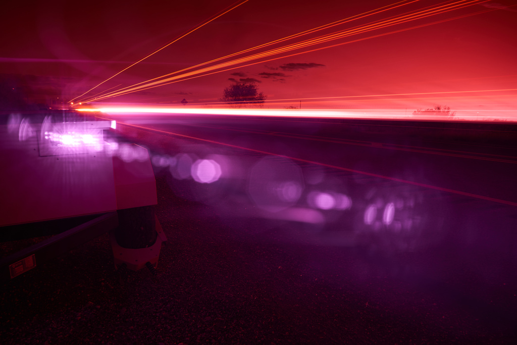 An infrared beam of light shines out of an automatic license plate reader recording vehicles passing along U.S. Highway 83, Oct. 13, 2025, in Laredo, Texas. (AP Photo/David Goldman)