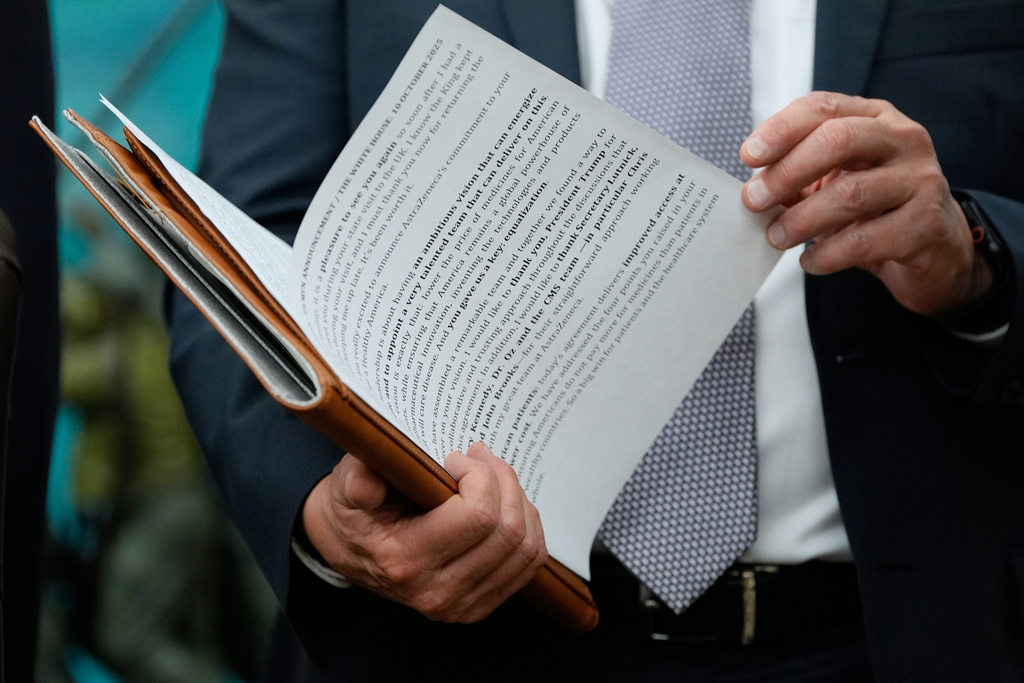 AstraZeneca CEO Pascal Soriot checks his notes before speaking at an event President Donald Trump in the Oval Office of the White House, Friday, Oct. 10, 2025, in Washington. (AP Photo/Alex Brandon)