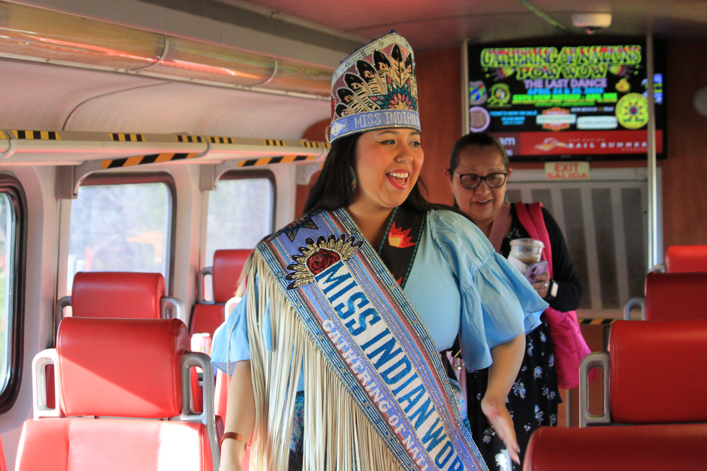 Miss Indian World Dania Wahwasuck greets morning commuters on the Rail Runner Express train after departing Albuquerque, New Mexico, on Tuesday, April 21, 2026. (AP Photo/Susan Montoya Bryan)