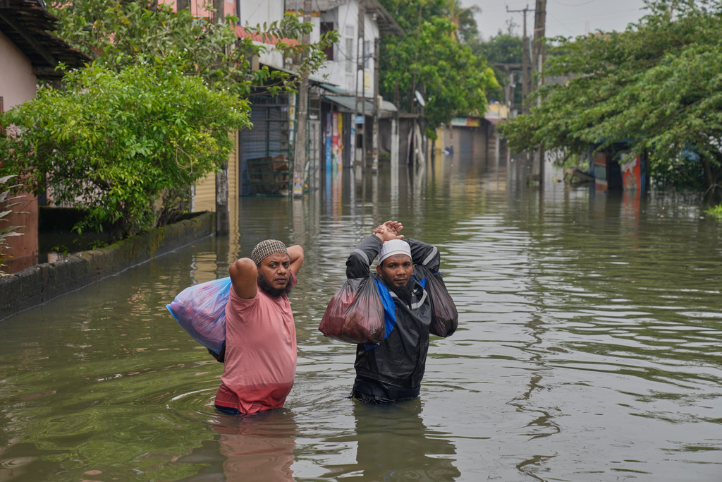Flood victims wade through water in Colombo, Sri Lanka, Saturday, Nov, 29, 2025. (AP Photo/Eranga Jayawardena)