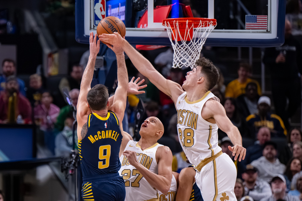 Boston Celtics guards Hugo Gonzalez (28) and Jordan Walsh (27) attempt to block a shot by Indiana Pacers guard T.J. McConnell (9) during the second half of an NBA basketball game in Indianapolis, Monday, Jan. 12, 2026. (AP Photo/Doug McSchooler)