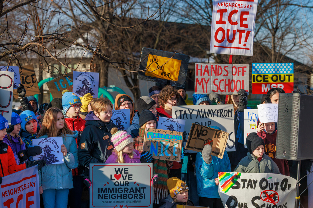 Minneapolis Public Schools families, educators and students hold signs during a news conference at Lake Hiawatha Park in Minneapolis, on Friday, Jan. 9, 2026, demanding Immigration and Customs Enforcement be kept out of schools and Minnesota following the killing of 37-year-old mother Renee Good by federal agents earlier on Wednesday. (Kerem Yücel/Minnesota Public Radio via AP)
