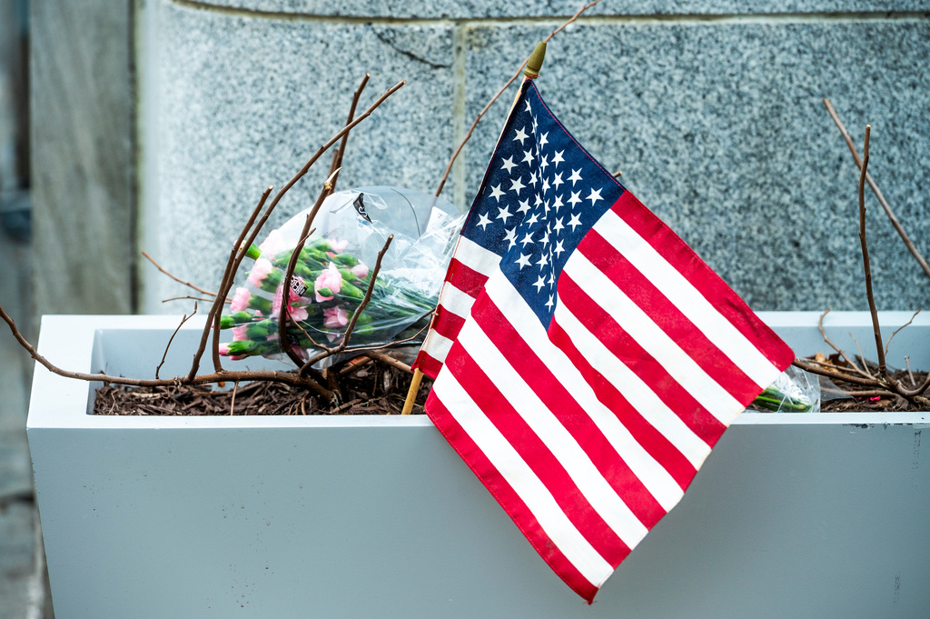 Flowers and an American flag, placed at the scene a day after two National Guard soldiers were shot near the White House in Washington, Thursday, Nov. 27, 2025. (AP Photo/Cliff Owen)